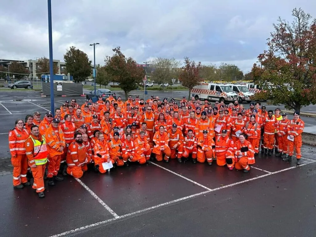 Large group of Fund VICSES campaign volunteers in orange rescue uniforms